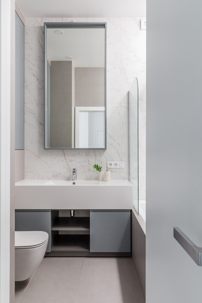 Источник вдохновения для домашнего уюта: главная ванная комната в современном стиле с плоскими фасадами, серыми фасадами, ванной в нише, белой плиткой, монолитной раковиной, бежевым полом и белой столешницей