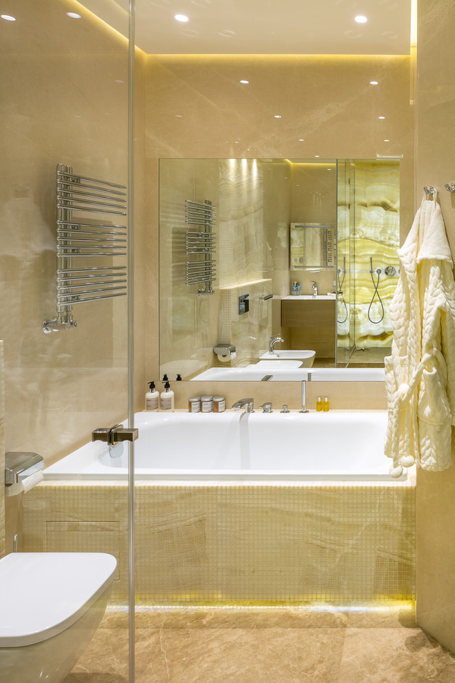 Idée de décoration pour une salle de bain principale design de taille moyenne avec WC suspendus, un carrelage beige, du carrelage en marbre, un sol en marbre, un sol beige et une baignoire en alcôve.
