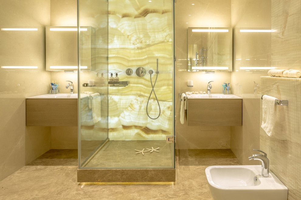 Cette image montre une salle de bain design de taille moyenne pour enfant avec un carrelage beige, du carrelage en marbre, un sol en marbre, un sol beige, une cabine de douche à porte battante, un placard à porte plane, un bidet et un lavabo intégré.