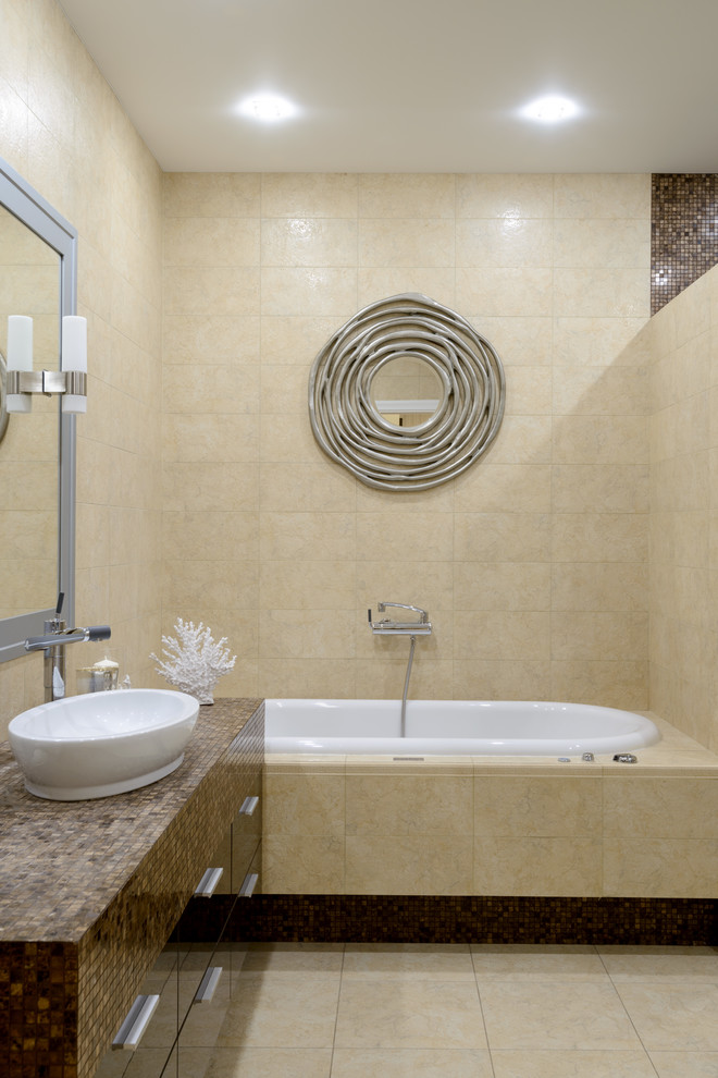 На фото: главная ванная комната в современном стиле с плоскими фасадами, накладной ванной, бежевой плиткой и настольной раковиной