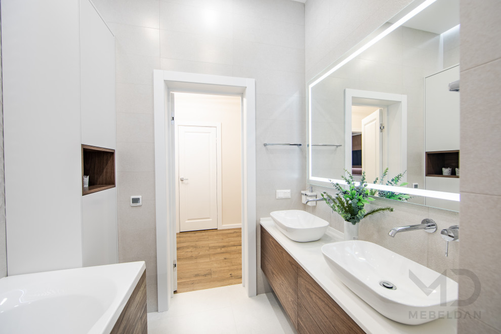 Diseño de cuarto de baño principal, doble y flotante actual de tamaño medio con puertas de armario marrones, bañera encastrada sin remate, sanitario de pared, encimera de acrílico y encimeras blancas
