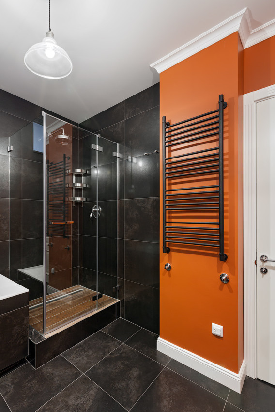 Источник вдохновения для домашнего уюта: большая ванная комната в современном стиле с полновстраиваемой ванной, угловым душем, инсталляцией, черной плиткой, керамогранитной плиткой, оранжевыми стенами, полом из керамогранита, врезной раковиной, черным полом, душем с распашными дверями и черной столешницей