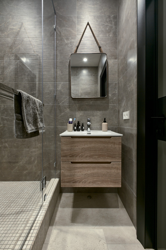 Immagine di una stanza da bagno con doccia contemporanea di medie dimensioni con ante lisce, ante in legno scuro, piastrelle grigie, lavabo integrato, un lavabo e mobile bagno sospeso