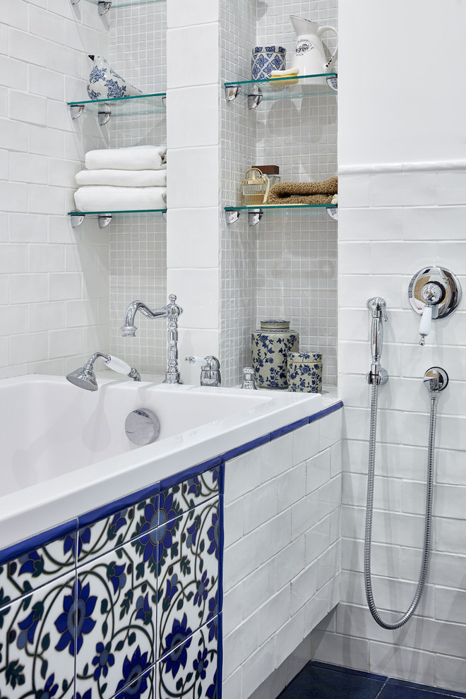 Immagine di una piccola stanza da bagno bohémian con piastrelle bianche, piastrelle blu, piastrelle multicolore, piastrelle in ceramica, pareti bianche, pavimento con piastrelle in ceramica, vasca da incasso, vasca/doccia e WC sospeso