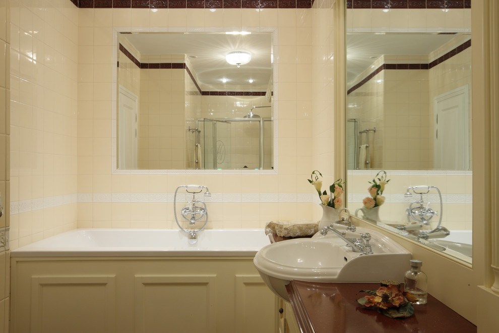 Идея дизайна: ванная комната в классическом стиле с ванной в нише, душем над ванной, бежевой плиткой и накладной раковиной