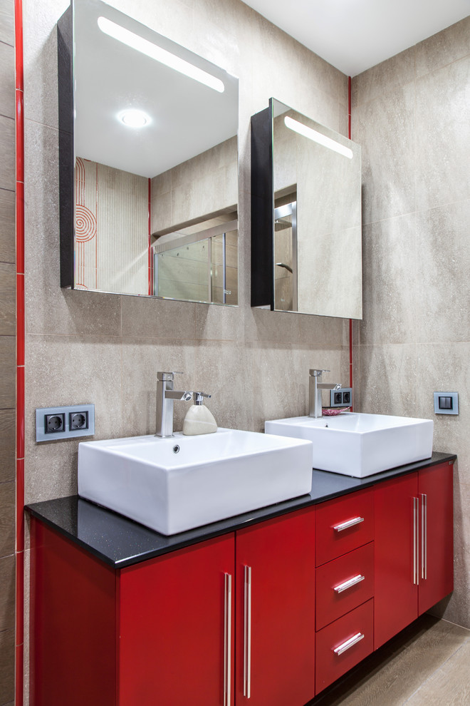На фото: главная ванная комната среднего размера в современном стиле с красными фасадами, серой плиткой, керамогранитной плиткой, серыми стенами, полом из керамогранита, настольной раковиной, столешницей из искусственного кварца, плоскими фасадами и зеркалом с подсветкой с