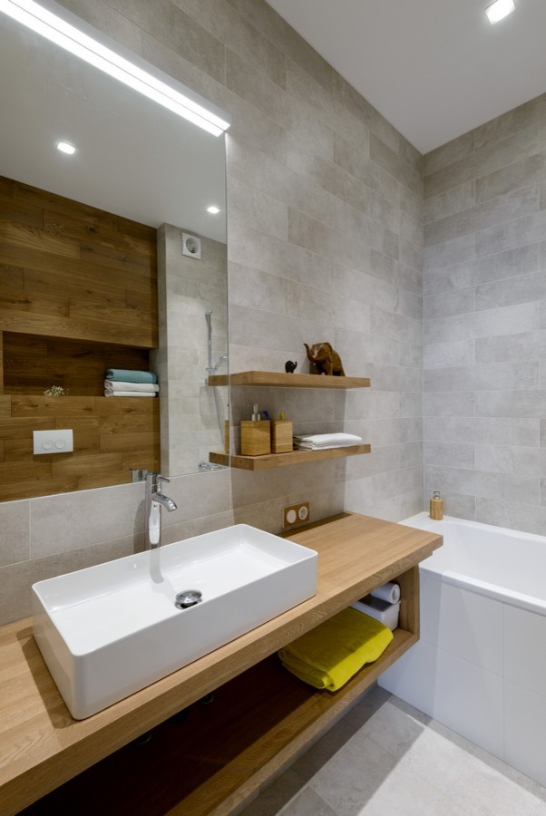 Стильный дизайн: главная ванная комната в современном стиле с открытыми фасадами, ванной в нише, коричневой плиткой, серой плиткой, настольной раковиной и столешницей из дерева - последний тренд
