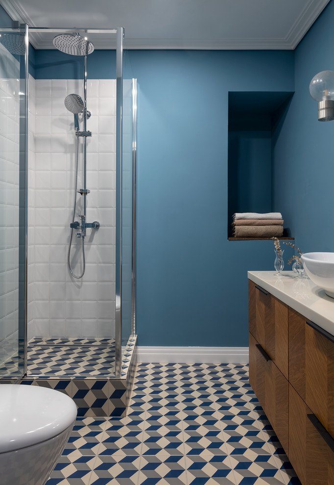 Diseño de cuarto de baño único retro con armarios con paneles lisos, puertas de armario de madera en tonos medios, paredes azules, aseo y ducha, lavabo sobreencimera, encimeras blancas y hornacina