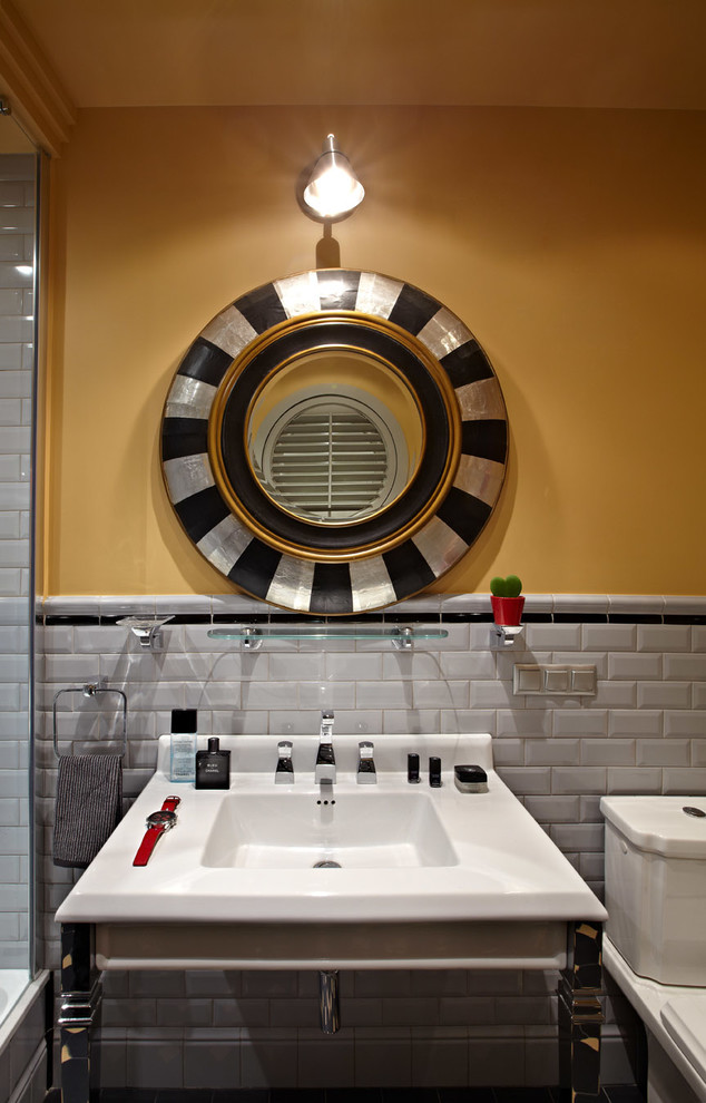 Esempio di una stanza da bagno contemporanea con piastrelle diamantate, pareti gialle e lavabo a consolle