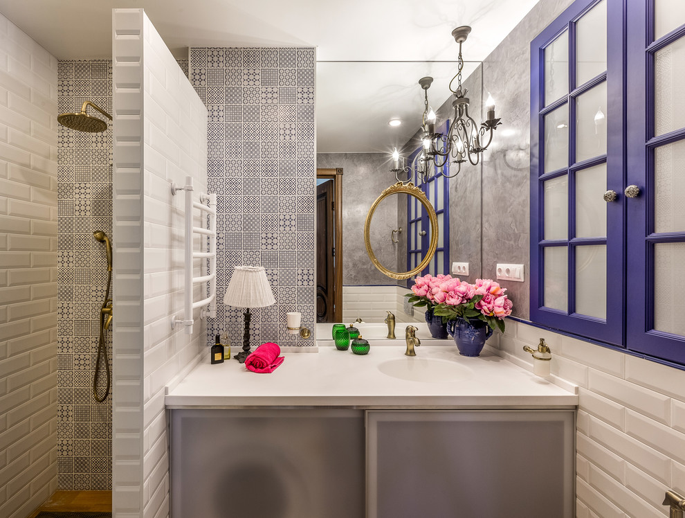 Cette image montre une petite salle de bain bohème avec un placard à porte plane, un carrelage blanc, un carrelage métro, un mur gris, un lavabo intégré, aucune cabine et un plan de toilette blanc.