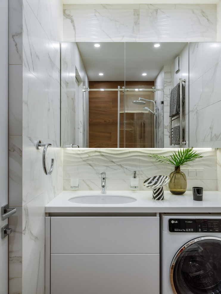 На фото: ванная комната в современном стиле с плоскими фасадами, белыми фасадами, белой плиткой, врезной раковиной и белой столешницей