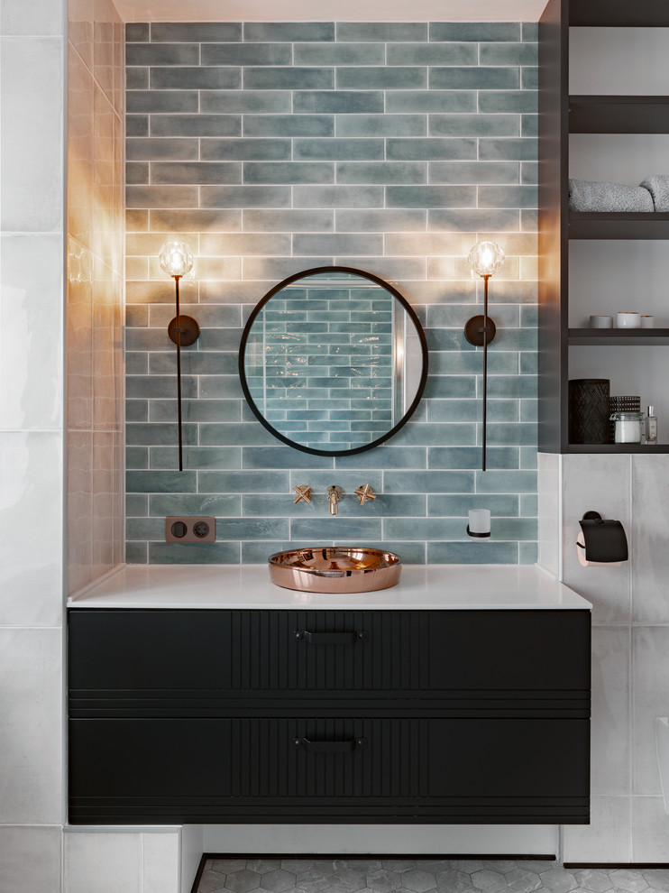 Modernes Badezimmer mit schwarzen Schränken, blauen Fliesen, Metrofliesen, blauer Wandfarbe, Aufsatzwaschbecken, grauem Boden und weißer Waschtischplatte in Sonstige