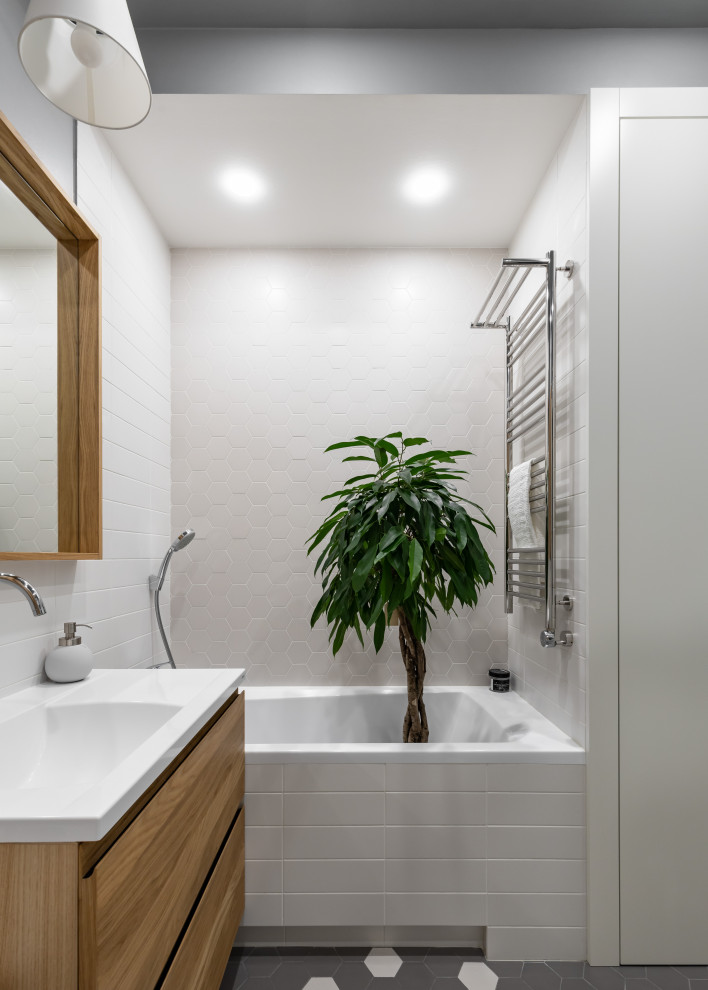 Idée de décoration pour une salle de bain nordique de taille moyenne avec un placard à porte plane, des portes de placard marrons, une baignoire en alcôve, une douche d'angle, WC suspendus, un carrelage blanc, des carreaux de céramique, un mur gris, un sol en carrelage de céramique, un lavabo de ferme, un plan de toilette en surface solide, un sol gris, une cabine de douche à porte coulissante et un plan de toilette blanc.