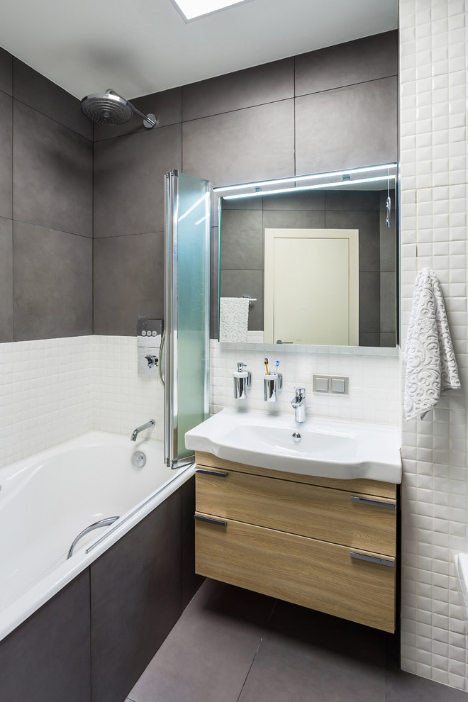 Design ideas for a contemporary bathroom with flat-panel cabinets and light wood cabinets.