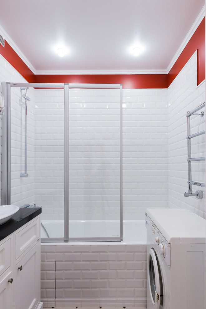 На фото: главная ванная комната в скандинавском стиле с фасадами с утопленной филенкой, белыми фасадами, ванной в нише, душем над ванной, красными стенами, настольной раковиной и черной столешницей