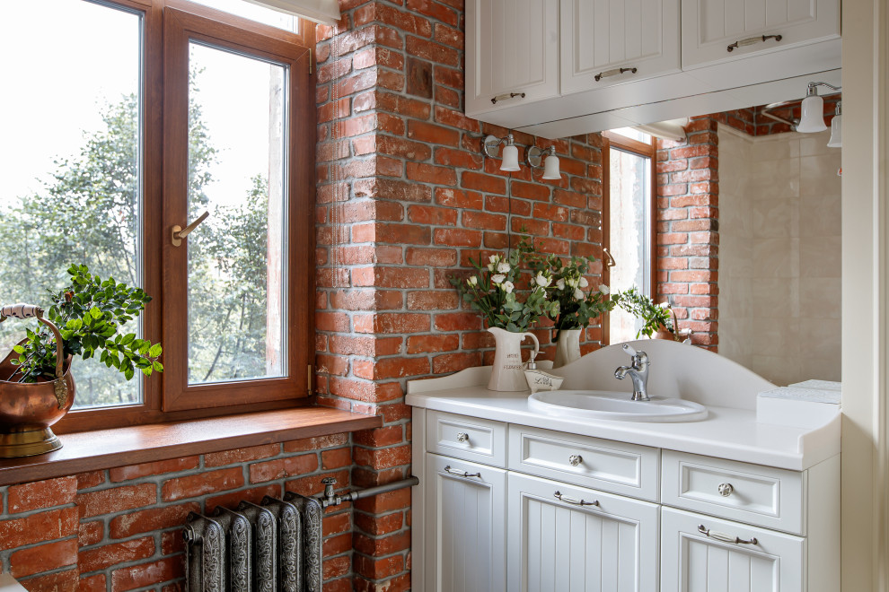 Aménagement d'une salle de bain classique avec un placard avec porte à panneau encastré, des portes de placard blanches, un lavabo posé et un plan de toilette blanc.