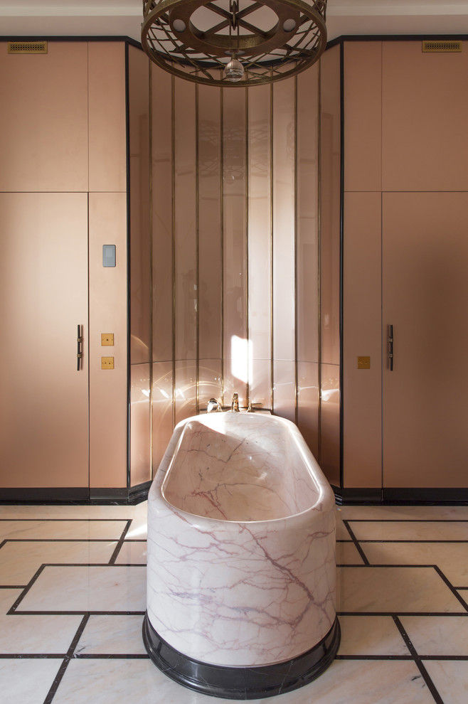 Cette image montre une salle de bain principale bohème avec une baignoire indépendante et un mur rose.