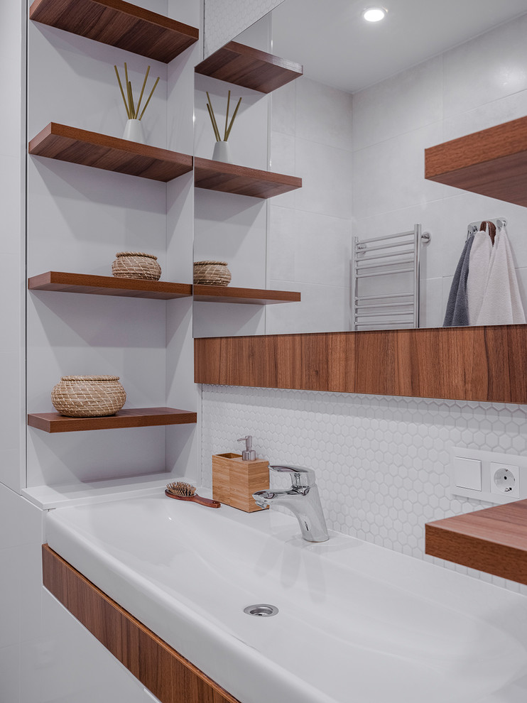 Идея дизайна: ванная комната в современном стиле с плоскими фасадами, фасадами цвета дерева среднего тона, белой плиткой, плиткой мозаикой, белыми стенами и консольной раковиной