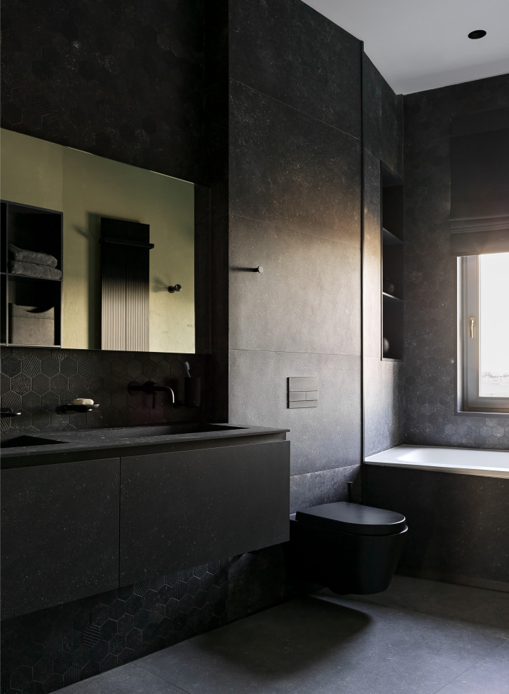 Bild på ett stort funkis svart svart badrum med dusch, med släta luckor, svarta skåp, ett platsbyggt badkar, en dusch i en alkov, ett urinoar, svart kakel, porslinskakel, svarta väggar, klinkergolv i porslin, ett undermonterad handfat och svart golv