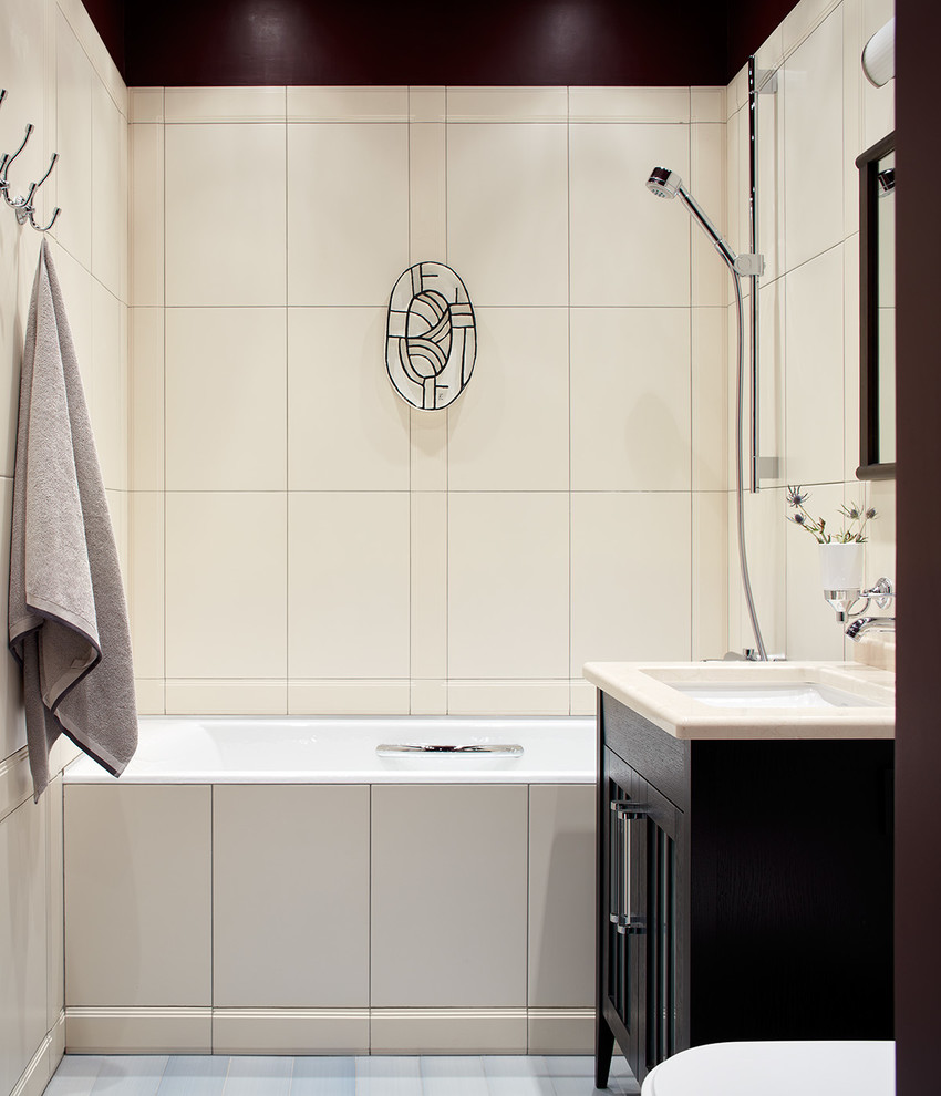 Bild på ett vintage beige beige en-suite badrum, med ett badkar i en alkov, en dusch/badkar-kombination, beige kakel, ett undermonterad handfat, grått golv, svarta skåp, beige väggar och luckor med glaspanel