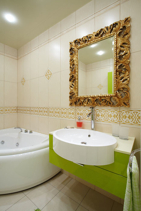 Aménagement d'une salle de bain principale contemporaine avec des portes de placards vertess, un placard à porte plane, un bain bouillonnant, un carrelage beige et un lavabo posé.