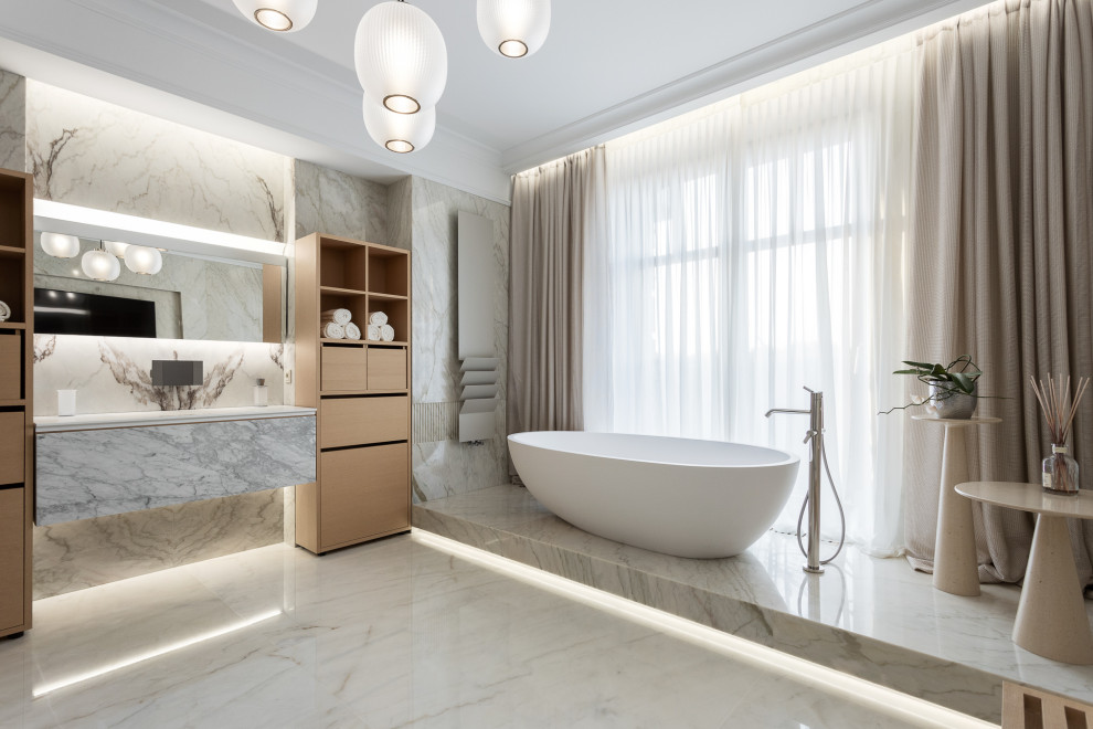 На фото: большая главная ванная комната в современном стиле с плоскими фасадами, серыми фасадами, отдельно стоящей ванной, серой плиткой, серым полом и белой столешницей