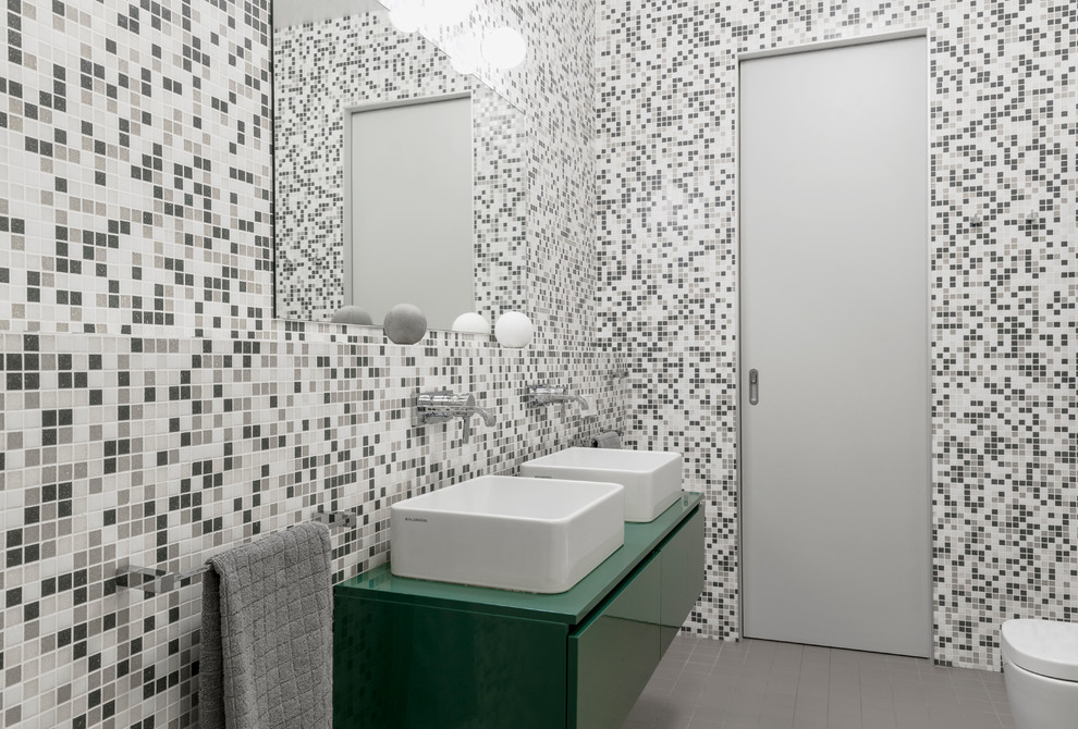 Идея дизайна: главная ванная комната среднего размера в современном стиле с плоскими фасадами, зелеными фасадами, отдельно стоящей ванной, инсталляцией, серой плиткой, плиткой мозаикой, серыми стенами, полом из цементной плитки, настольной раковиной, столешницей из ламината, серым полом и зеленой столешницей