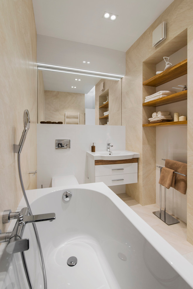 Cette photo montre une salle de bain principale tendance avec un placard à porte plane, des portes de placard blanches, WC séparés, un carrelage beige et un lavabo suspendu.