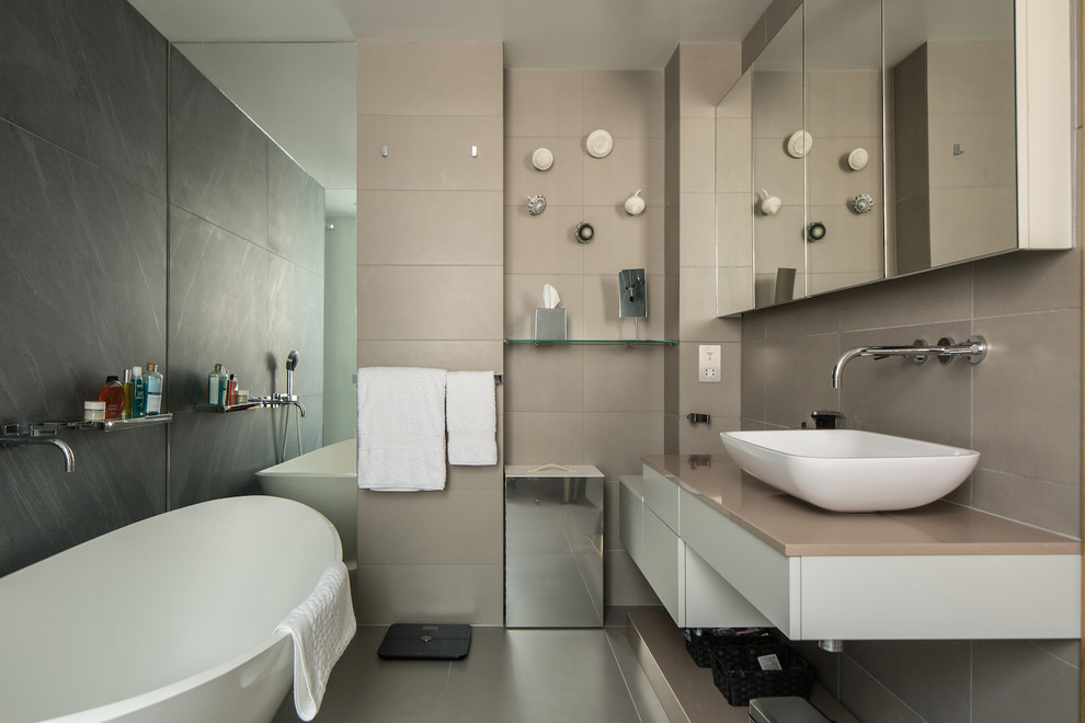 Medium sized contemporary ensuite bathroom in Saint Petersburg with flat-panel cabinets, white cabinets, a freestanding bath, beige tiles, grey tiles, a vessel sink, grey floors and beige worktops.
