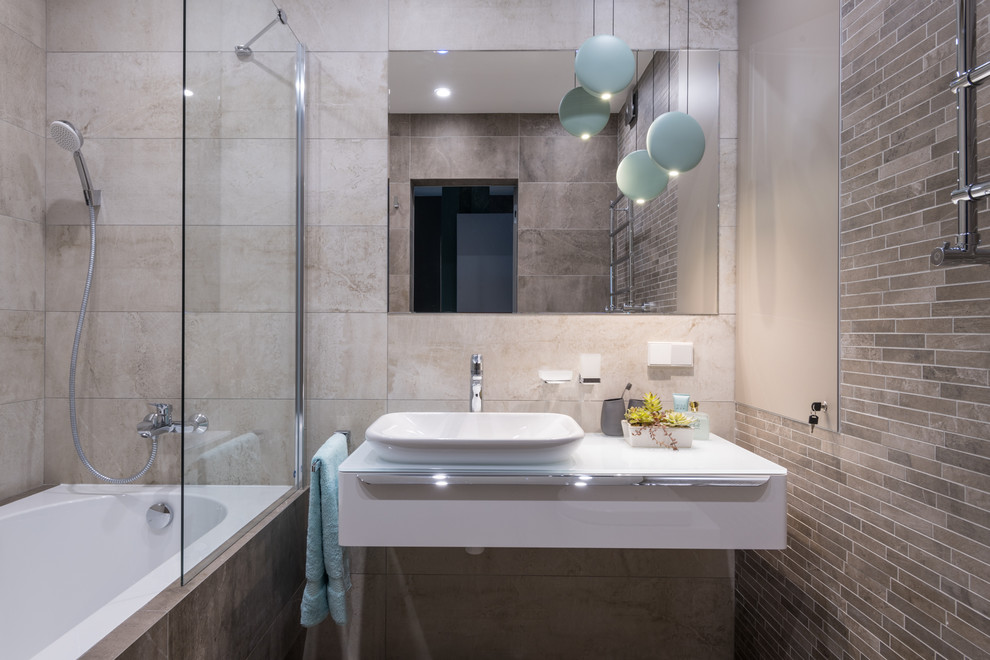 На фото: главная ванная комната в современном стиле с плоскими фасадами, белыми фасадами, душем над ванной, бежевой плиткой, белой столешницей и зеркалом с подсветкой