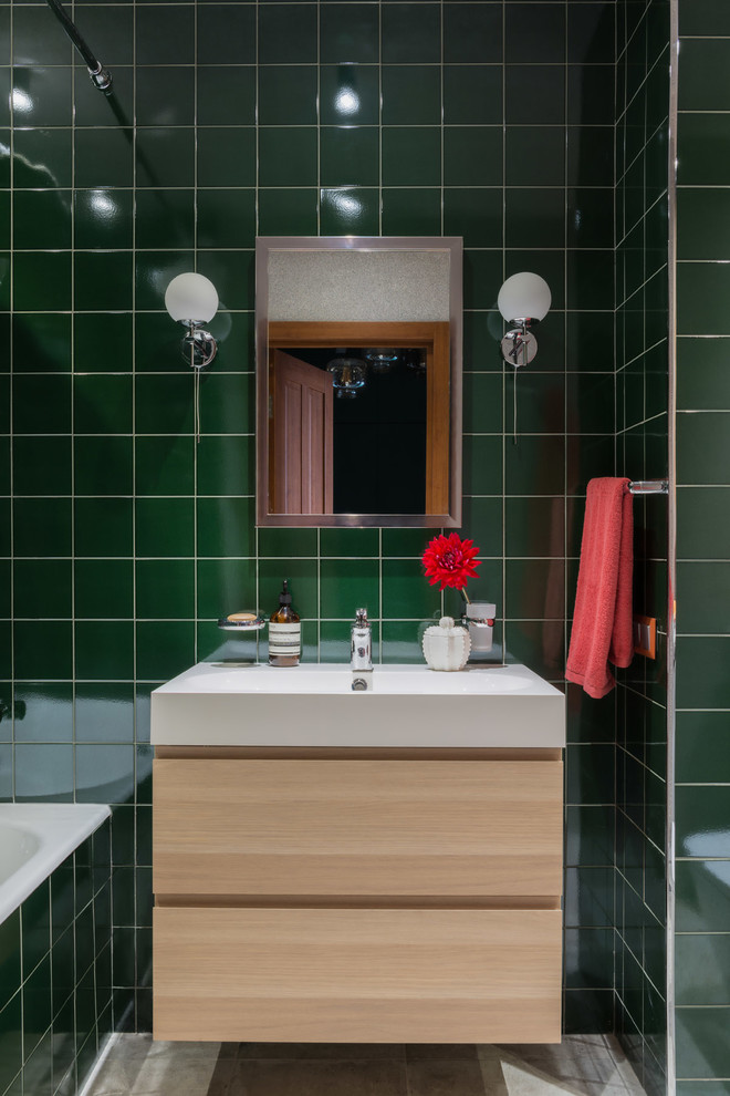 Réalisation d'une salle de bain principale design en bois clair avec un placard à porte plane, une baignoire en alcôve, un combiné douche/baignoire, un carrelage vert, un lavabo posé, un sol gris, une cabine de douche avec un rideau et un mur vert.