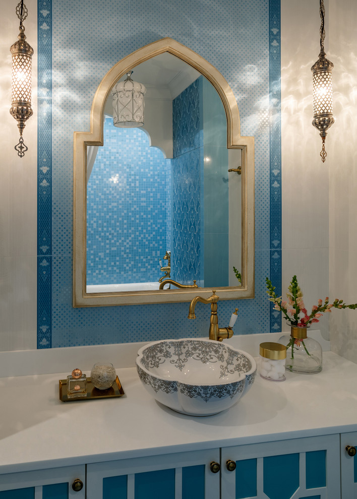 Imagen de cuarto de baño asiático de tamaño medio con armarios con paneles con relieve, puertas de armario turquesas, baldosas y/o azulejos azules, baldosas y/o azulejos de cerámica, lavabo sobreencimera y encimera de acrílico