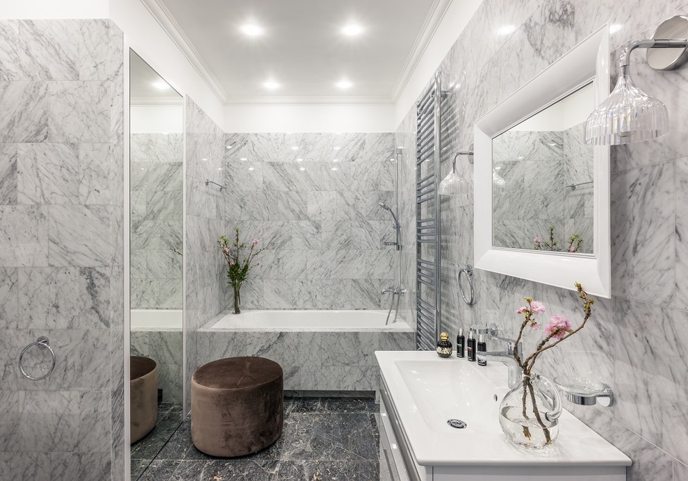 Пример оригинального дизайна: главная ванная комната в современном стиле с плоскими фасадами, белыми фасадами, ванной в нише, серой плиткой, монолитной раковиной и серым полом