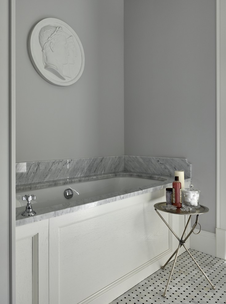 На фото: ванная комната в классическом стиле с полновстраиваемой ванной и серыми стенами с