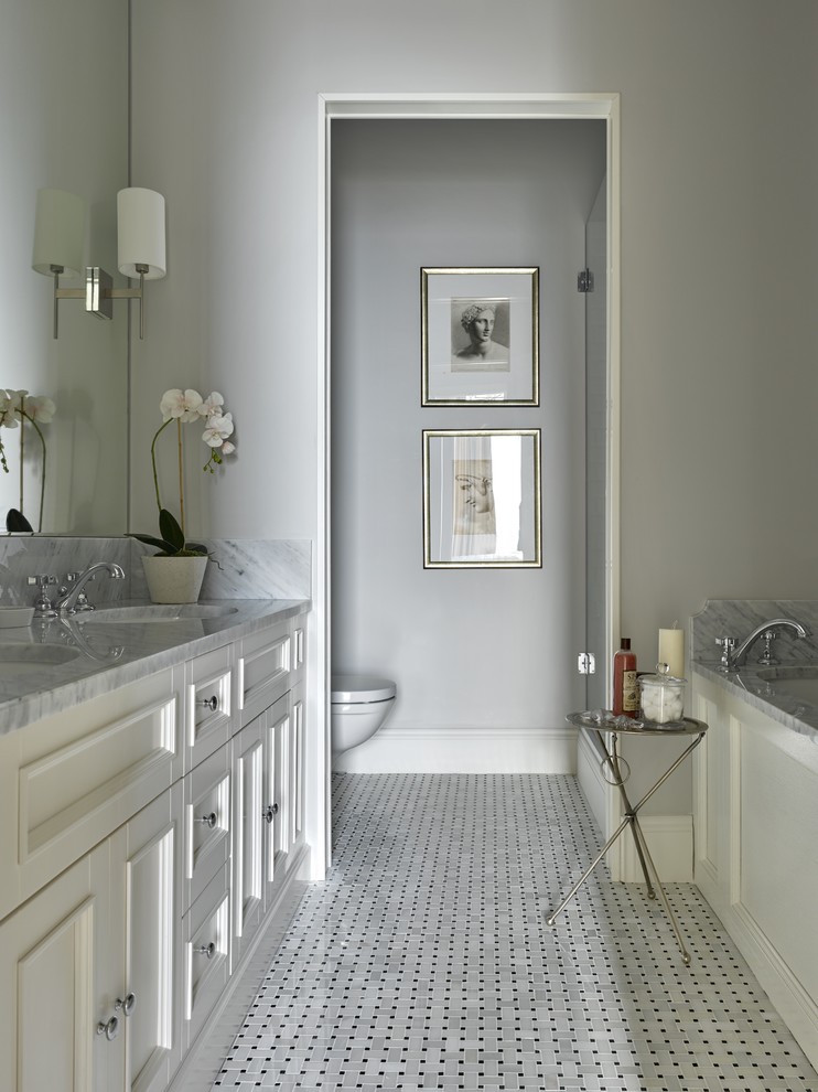 Bild på ett vintage en-suite badrum, med luckor med infälld panel, vita skåp, ett badkar i en alkov, en dusch i en alkov, en toalettstol med separat cisternkåpa, grå väggar och ett undermonterad handfat