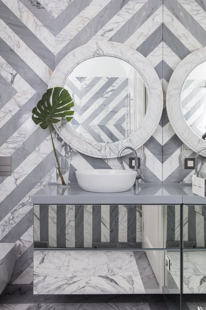 Foto di una stanza da bagno classica con WC sospeso, piastrelle grigie, ante lisce, piastrelle di marmo, lavabo a bacinella, pavimento grigio e top grigio