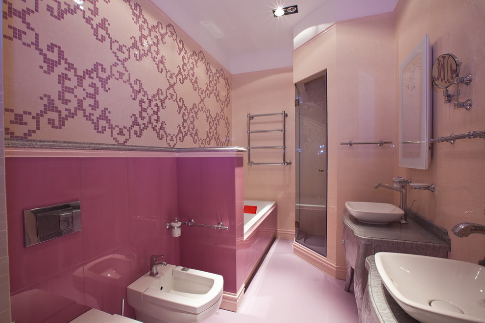 На фото: главная ванная комната среднего размера в стиле неоклассика (современная классика) с серыми фасадами, гидромассажной ванной, душевой комнатой, инсталляцией, керамической плиткой, розовыми стенами, полом из керамической плитки, настольной раковиной, столешницей из дерева, розовым полом, душем с распашными дверями и серой столешницей