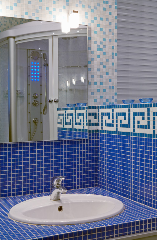 На фото: большая главная ванная комната в современном стиле с стеклянными фасадами, синими фасадами, гидромассажной ванной, душем над ванной, инсталляцией, синей плиткой, керамогранитной плиткой, синими стенами, полом из керамогранита, врезной раковиной и столешницей из плитки