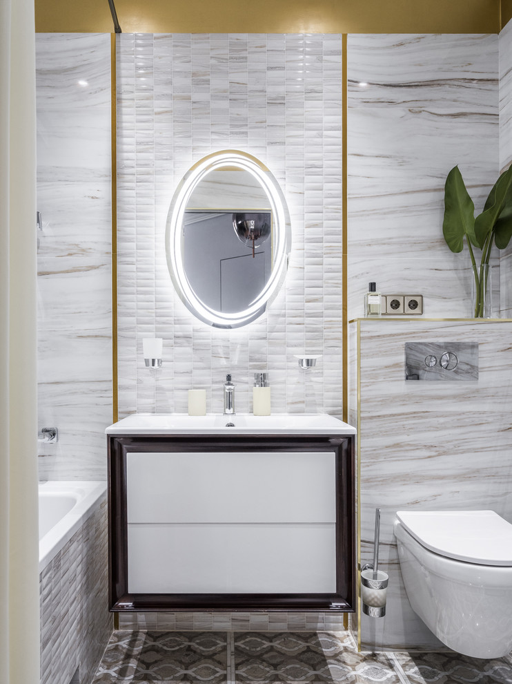 Свежая идея для дизайна: главная ванная комната в современном стиле с плоскими фасадами, белыми фасадами, ванной в нише, душем над ванной, инсталляцией, монолитной раковиной и серым полом - отличное фото интерьера