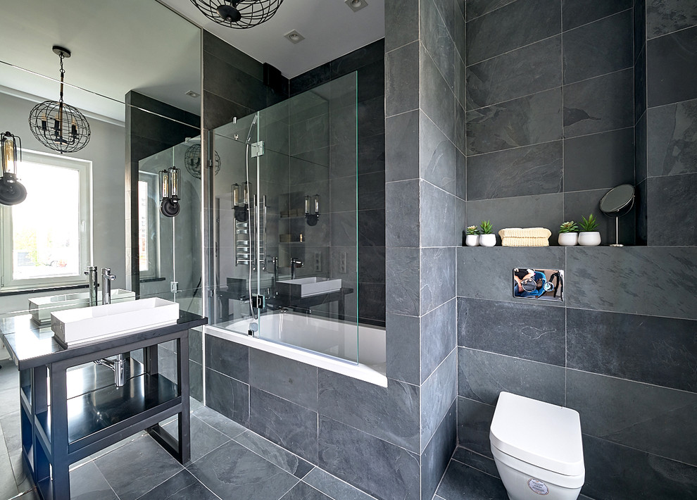 Источник вдохновения для домашнего уюта: главная ванная комната в современном стиле с ванной в нише, душем над ванной, серой плиткой, настольной раковиной и черной столешницей