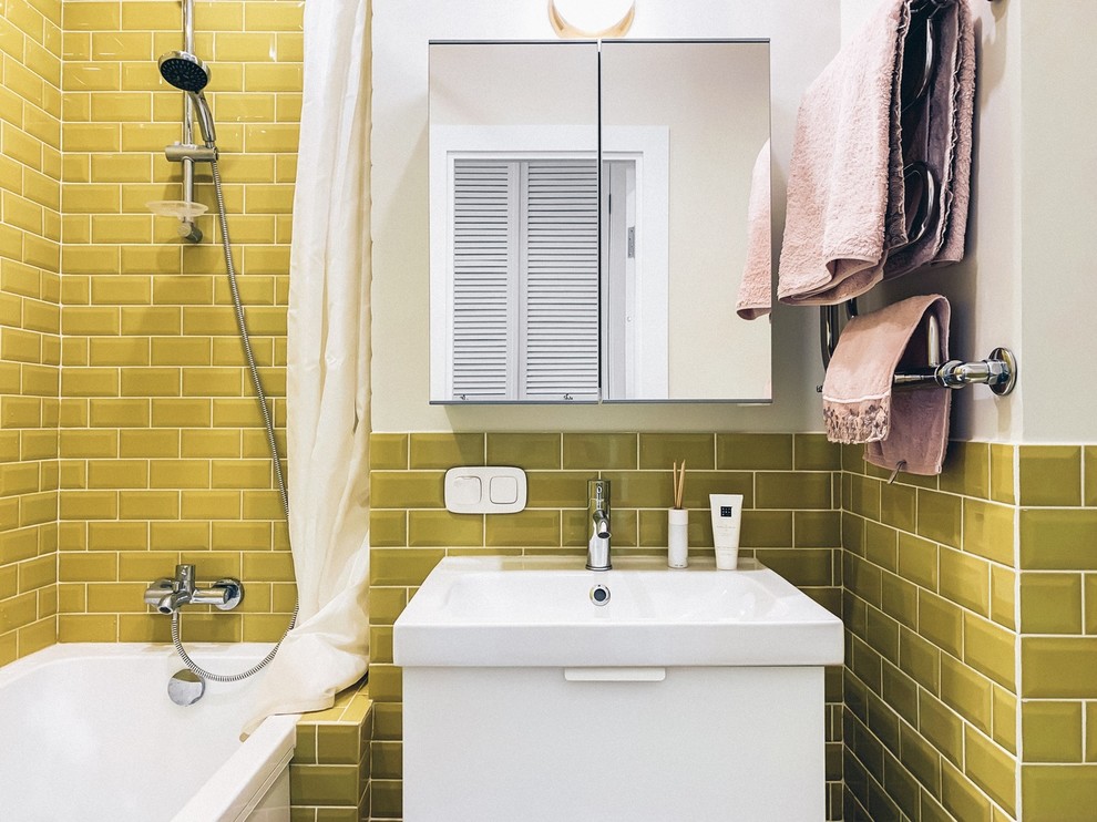 Пример оригинального дизайна: маленькая главная ванная комната в скандинавском стиле с плоскими фасадами, белыми фасадами, полновстраиваемой ванной, раздельным унитазом, белыми стенами и подвесной раковиной для на участке и в саду