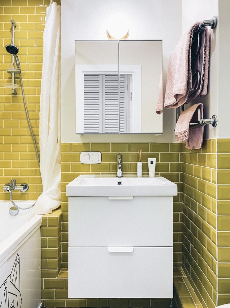 На фото: маленькая главная ванная комната в скандинавском стиле с плоскими фасадами, белыми фасадами, полновстраиваемой ванной, раздельным унитазом, белыми стенами и подвесной раковиной для на участке и в саду