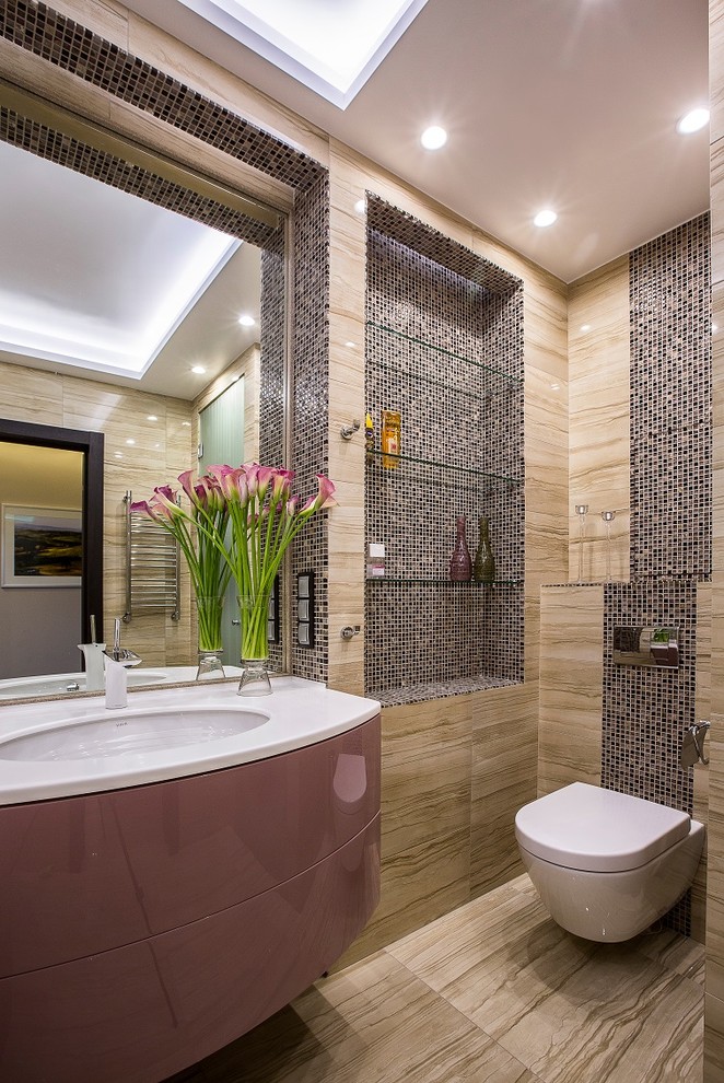 Aménagement d'une salle de bain contemporaine avec un placard à porte plane, WC suspendus, un carrelage marron et un lavabo encastré.
