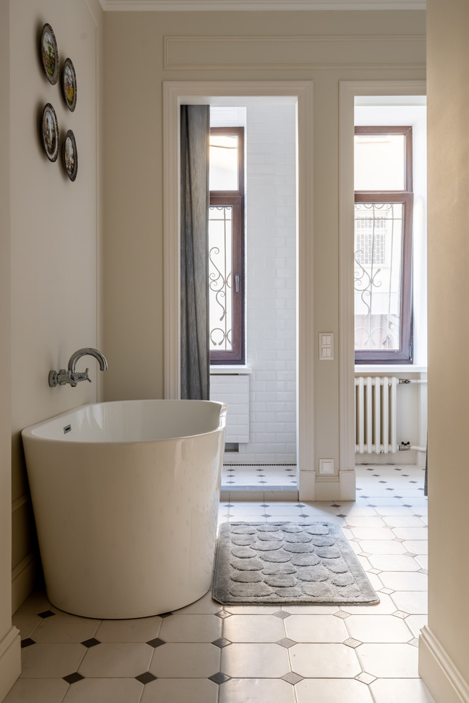 Cette image montre une grande salle de bain traditionnelle avec une baignoire indépendante, un carrelage blanc, un carrelage métro, un mur beige, un sol en carrelage de céramique, un sol blanc et une cabine de douche avec un rideau.