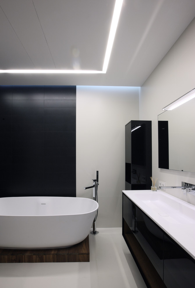 Inspiration for a contemporary ensuite bathroom in Moscow with a trough sink, flat-panel cabinets, black cabinets, a freestanding bath and white walls.