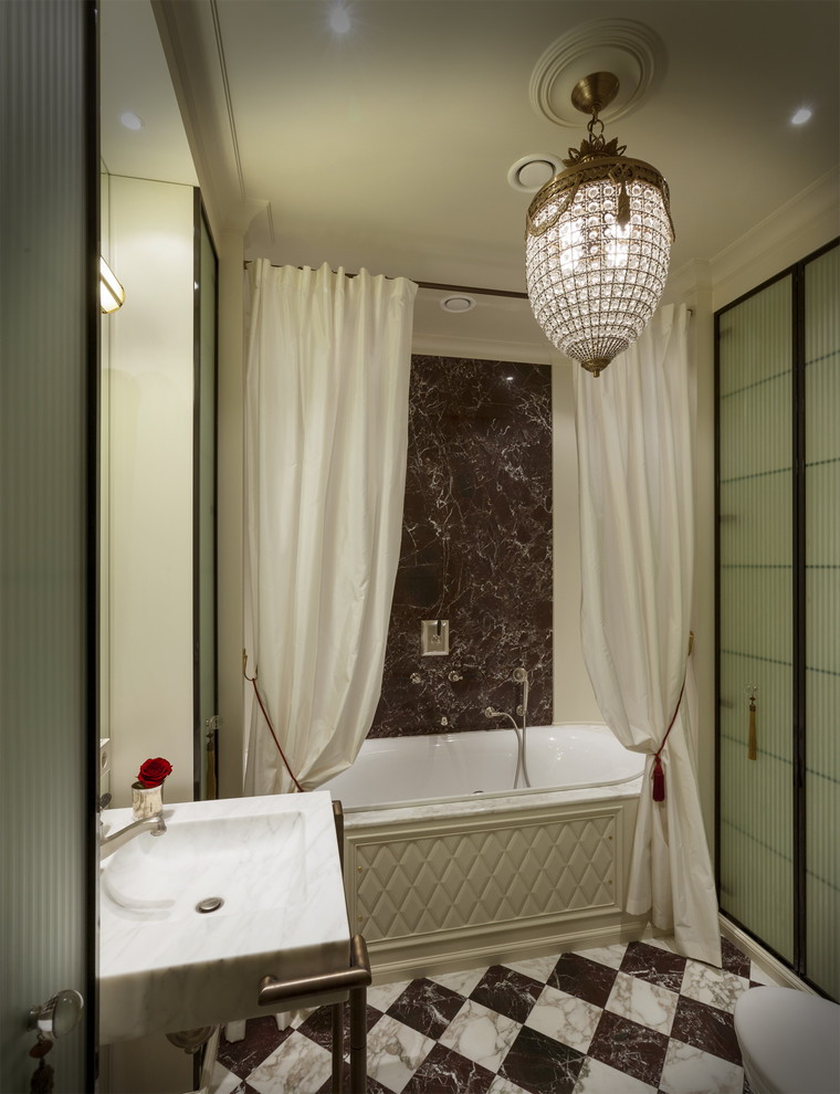 Modelo de cuarto de baño tradicional renovado con bañera empotrada, lavabo tipo consola y baldosas y/o azulejos marrones