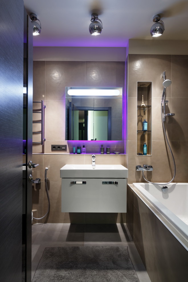 Foto på ett funkis en-suite badrum, med släta luckor, vita skåp, en dusch/badkar-kombination, beige kakel, beige väggar, ett väggmonterat handfat och ett platsbyggt badkar