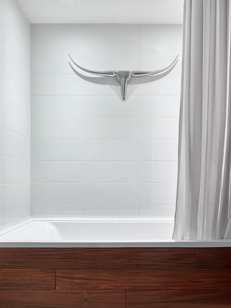 Immagine di una stanza da bagno scandinava con vasca ad alcova e piastrelle bianche