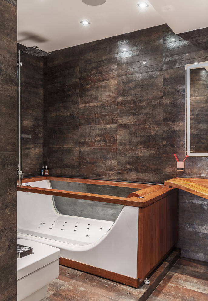 Diseño de cuarto de baño principal actual con baldosas y/o azulejos negros, lavabo suspendido y suelo marrón