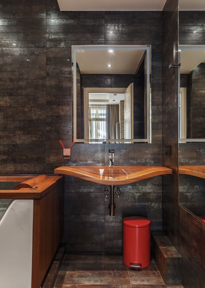 Ispirazione per una stanza da bagno padronale minimal con piastrelle nere, lavabo sospeso, pavimento marrone, top in legno e top marrone